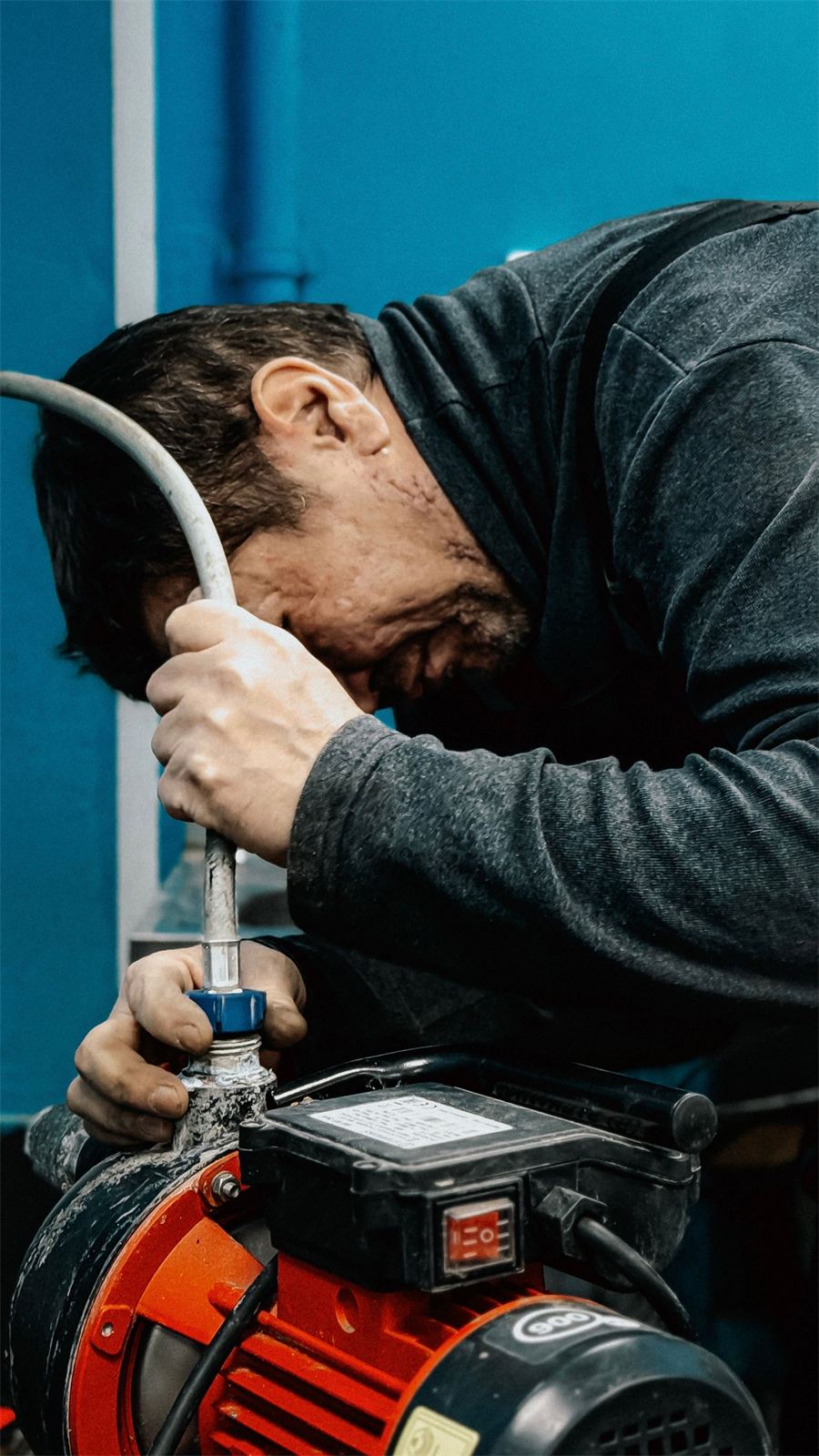 Técnico reparando una bomba de agua presurizadora